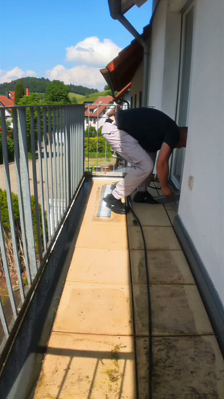 Ein Balkon wird nach dem Winter freigekehrt